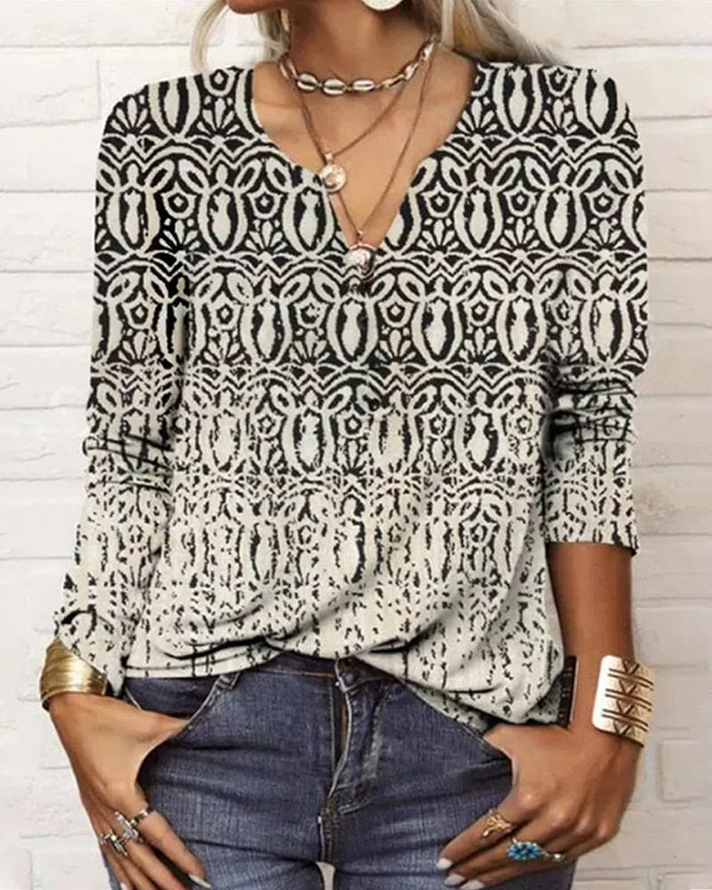 vrouw in bedrukte top met verschillende patronen en kleuren en lange mouwen