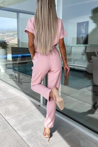 Ervaar moeiteloos comfort en verfijnde stijl met de Cassia jumpsuit. Deze veelzijdige outfit heeft een flatterende V-hals, elastische taille met stijlvolle riem en handige zakken. Gemaakt van zacht polyester voor een elegante val en de hele dag comfort. Beschikbaar in abrikoos, zwart, rozerood en roze, in maten XS tot XL. Ideaal voor werk, casual uitjes of weekendboodschappen. Upgrade je dagelijkse garderobe met de Cassia jumpsuit.