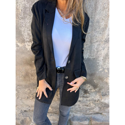 vrouw in lange getailleerde jas met reverskraag en knoopsluiting