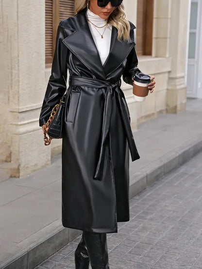 Sefina Overjas: een elegante imitatieleren jas met een open ontwerp en een tailleceintuur voor een flatterend silhouet. Perfect voor speciale gelegenheden, zakelijke events of om je dagelijkse look te verfijnen. Gemaakt van hoogwaardig kunstleer en polyester voor comfort, warmte en duurzaamheid. De klassieke zwarte kleur blijft tijdloos stijlvol. Verkrijgbaar in S-L. Upgrade je garderobe met de Sefina overjas en straal moeiteloze luxe en verfijning uit!