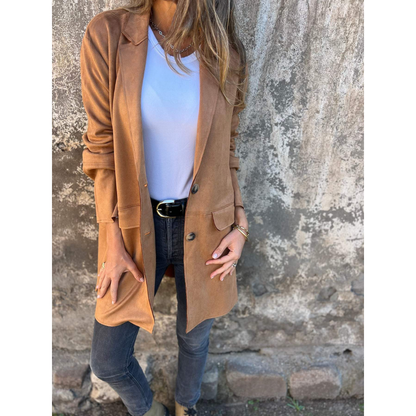 vrouw in lange getailleerde jas met reverskraag en knoopsluiting